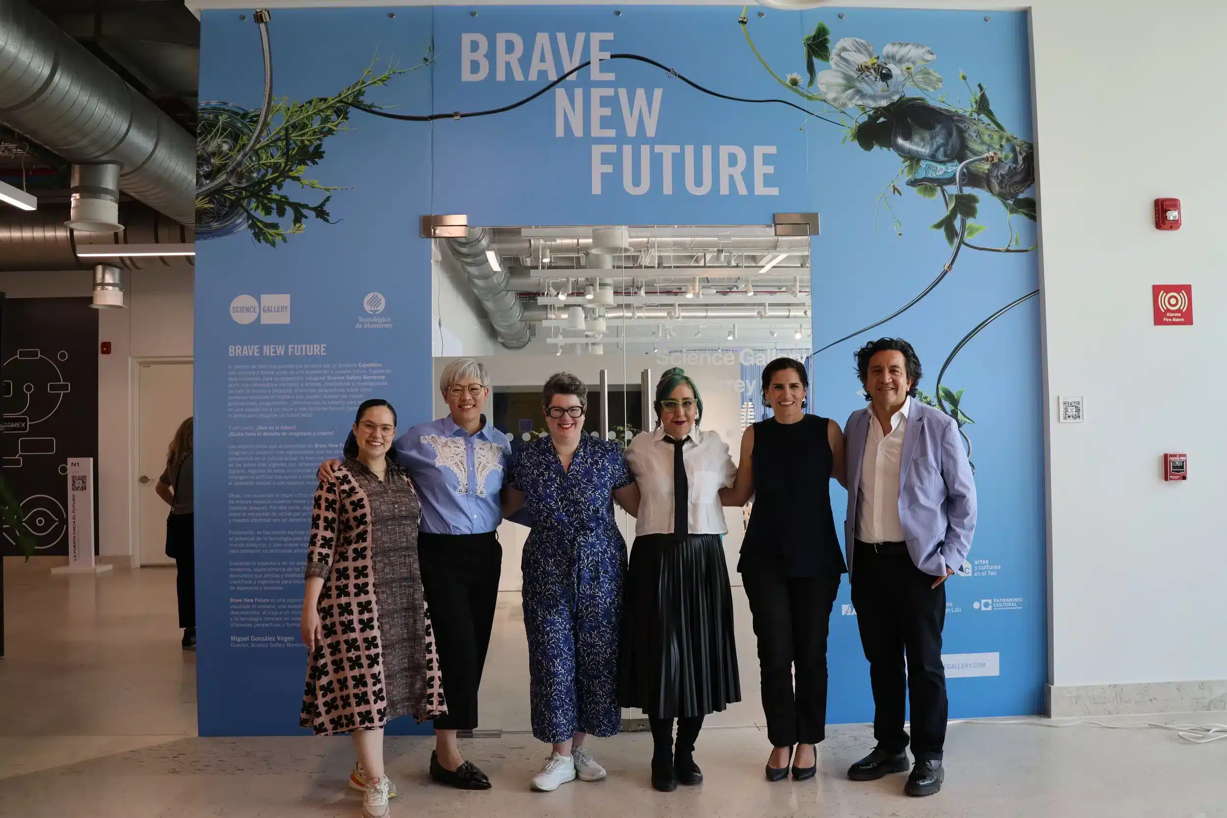 Grupo de personas frente a un mural con la frase BRAVE NEW FUTURE, simbolizando innovación y colaboración en el Founder Summit