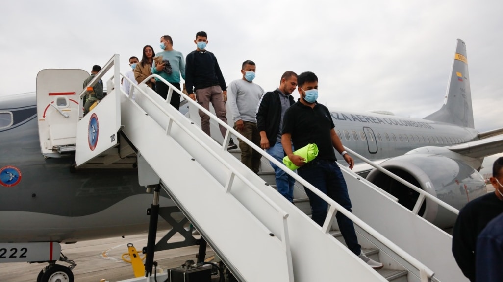 Personas descendiendo de un avión de deportación en Haití