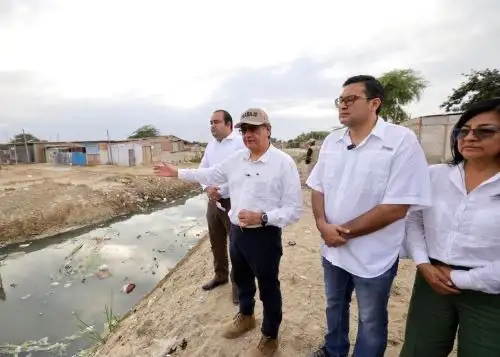 Cuatro personas observan un drenaje en mal estado en Piura durante la agenda de prevención