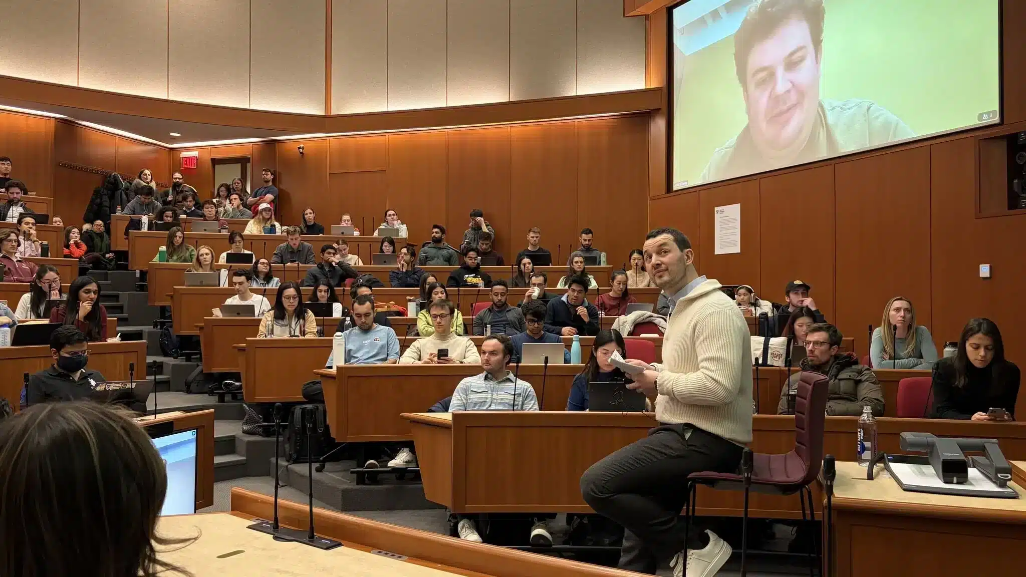 Aula con estudiantes y un presentador mostrando herramientas de IA