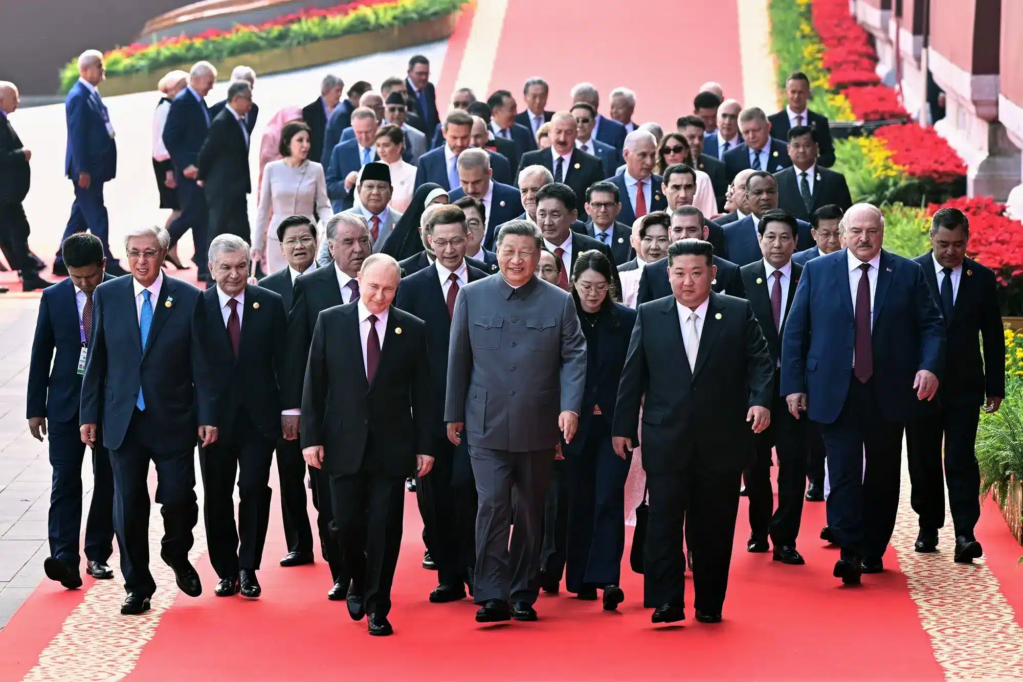 Líderes globales caminan juntos sobre la alfombra roja en un evento internacional