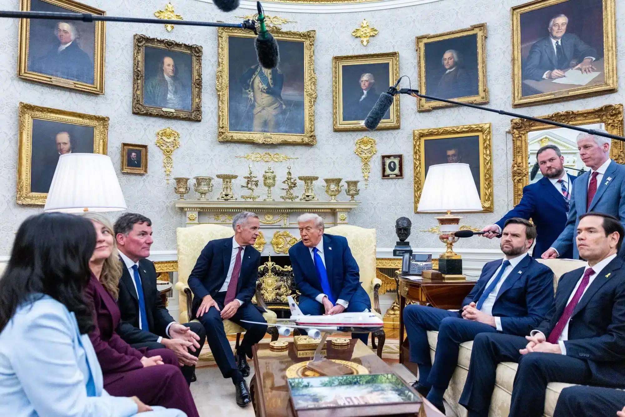 Reunión en un entorno formal con un modelo de avión sobre la mesa central