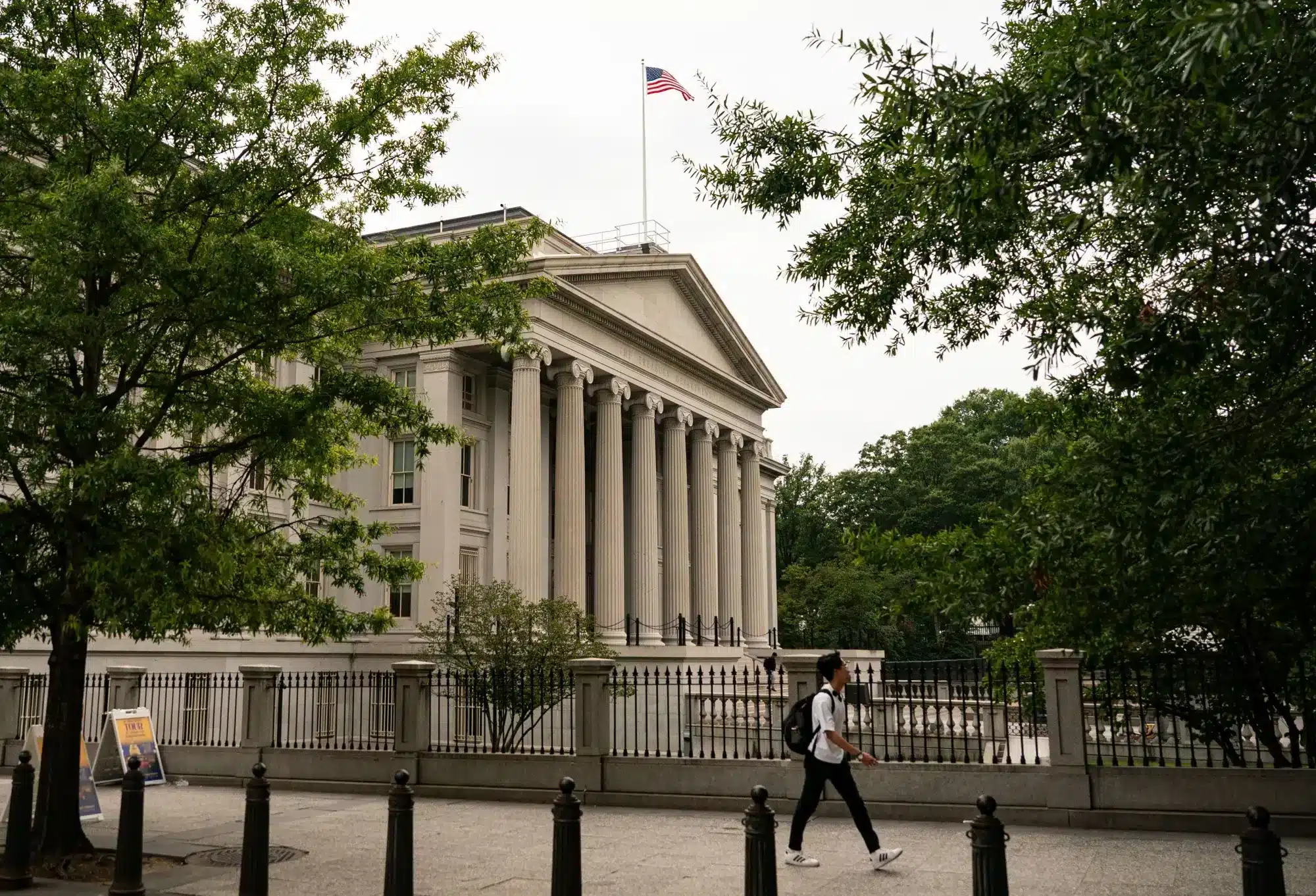 Edificio del Departamento del Tesoro de Estados Unidos con una bandera estadounidense ondeando en la parte superior