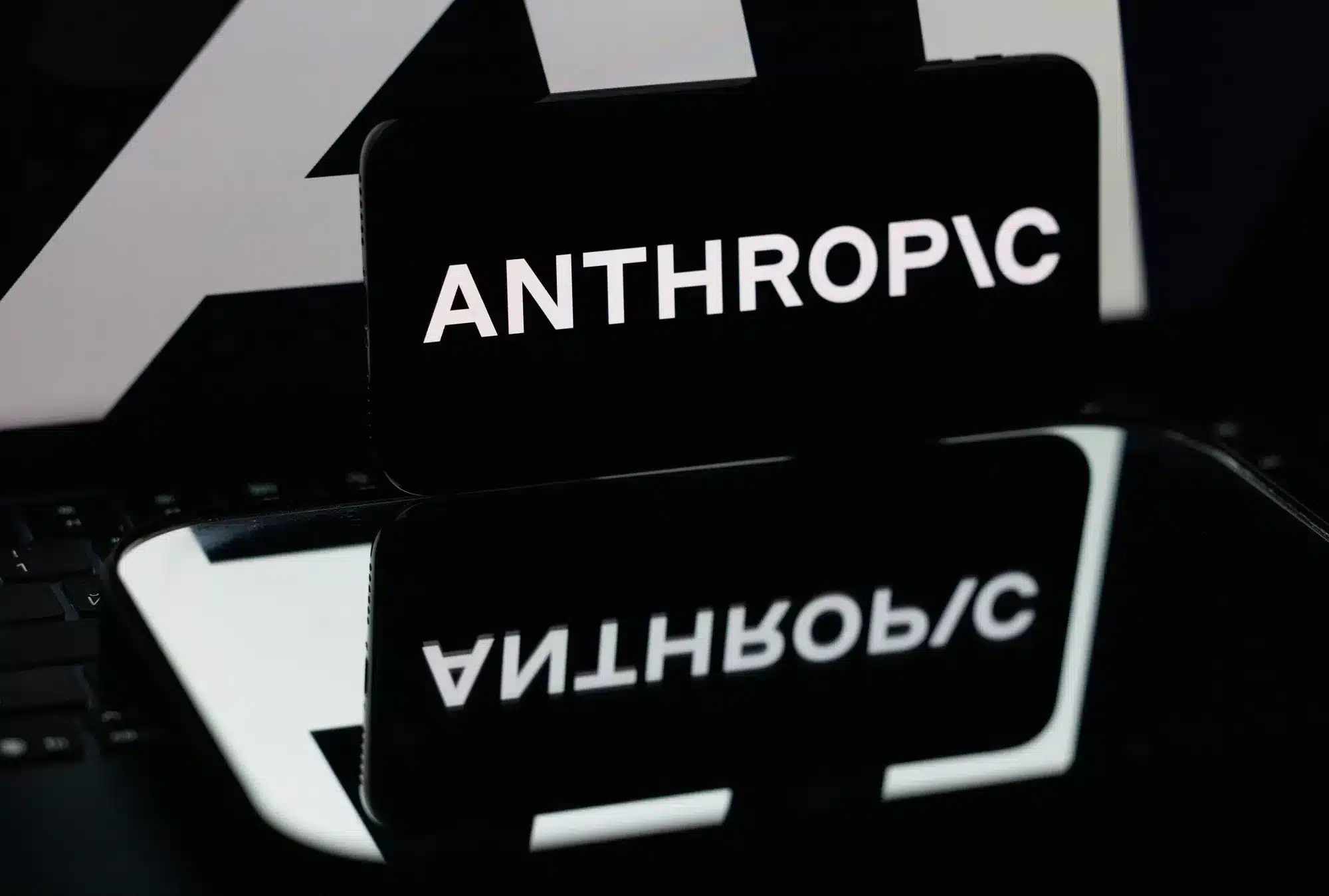 Smartphone con la palabra Anthropic sobre una superficie reflectante