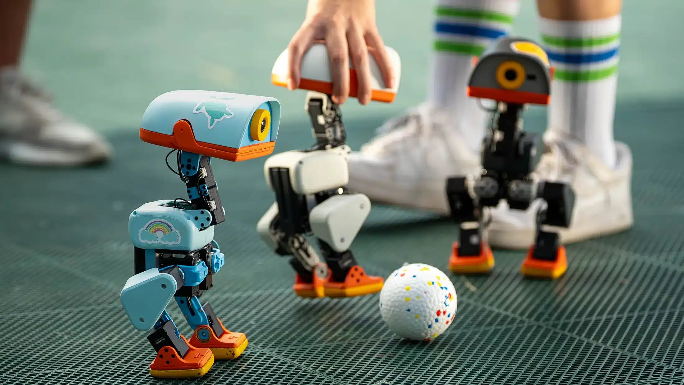Varios robots Microduck en un entorno de pruebas de color verde
