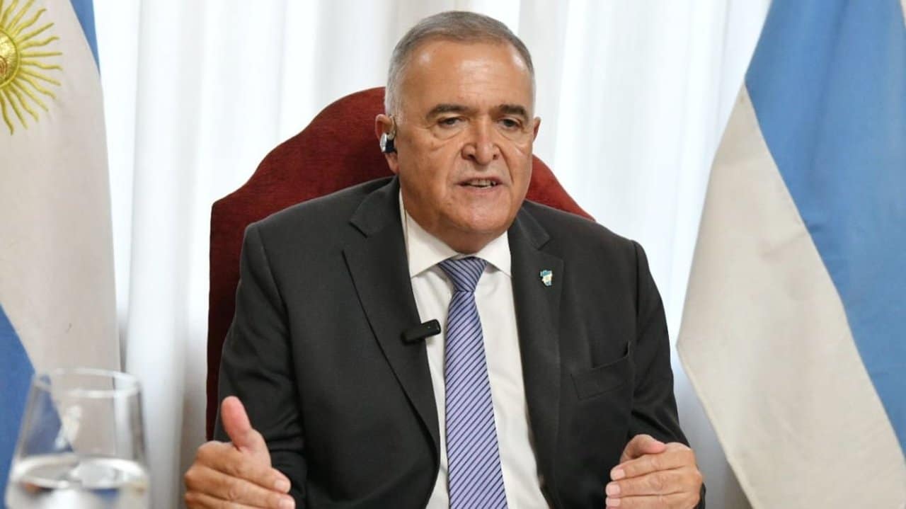 Gobernador Osvaldo Jaldo durante una conferencia con banderas argentinas