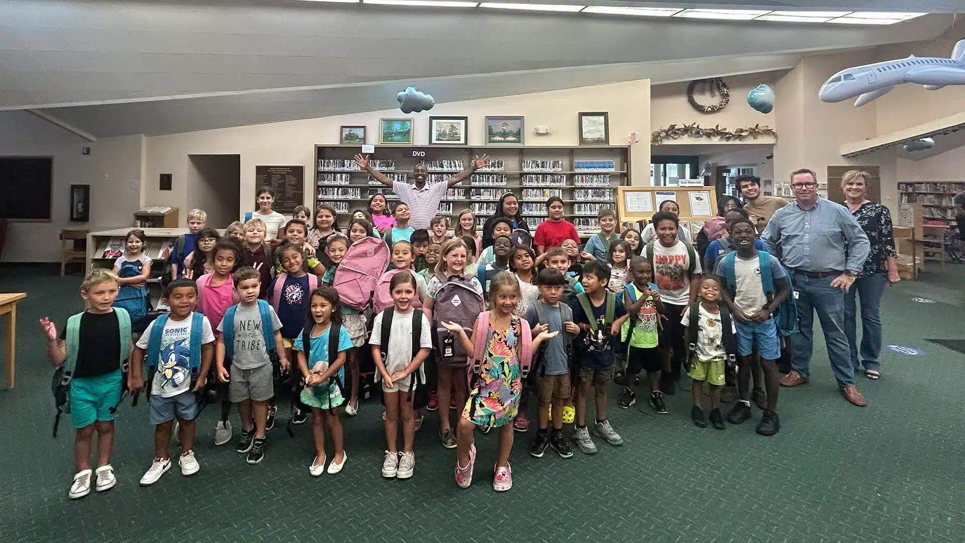 Estudiantes con mochilas en una biblioteca durante un evento de regreso a clases en South Florida