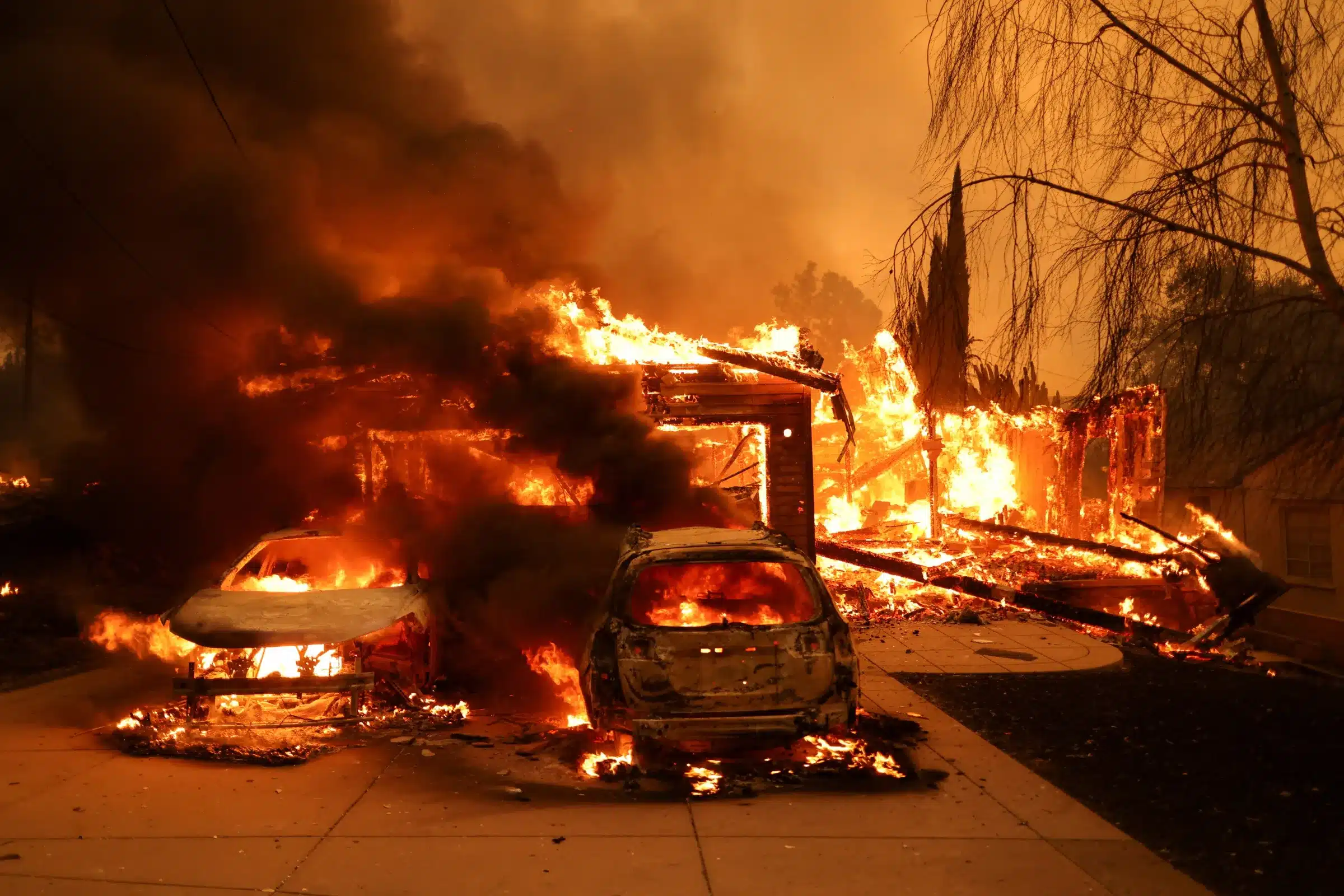 Casas en llamas y vehículos quemados durante un incendio forestal en Los Ángeles