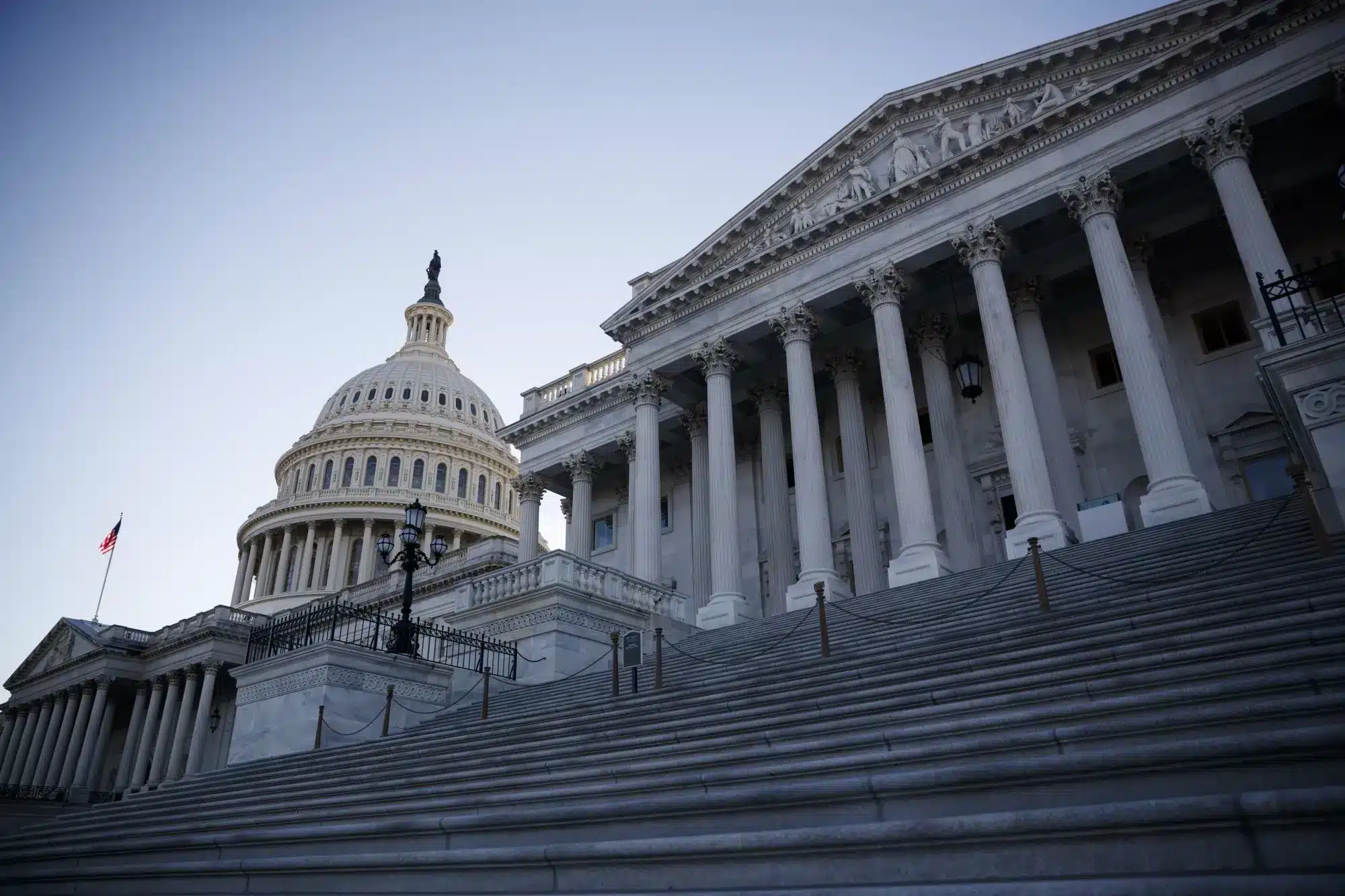 Perspectiva del Capitolio de Estados Unidos con su cúpula y la bandera estadounidense ondeando