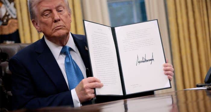 Trump sosteniendo un documento en una oficina oficial