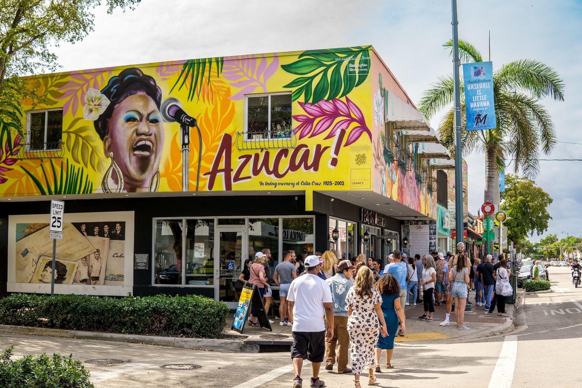 Mural de Celia Cruz en un edificio de Little Havana frente al cual hay personas haciendo fila