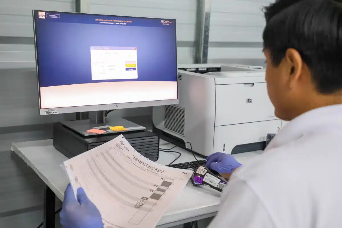 Trabajador revisa en computadora el sistema de control de impresión de actas electorales