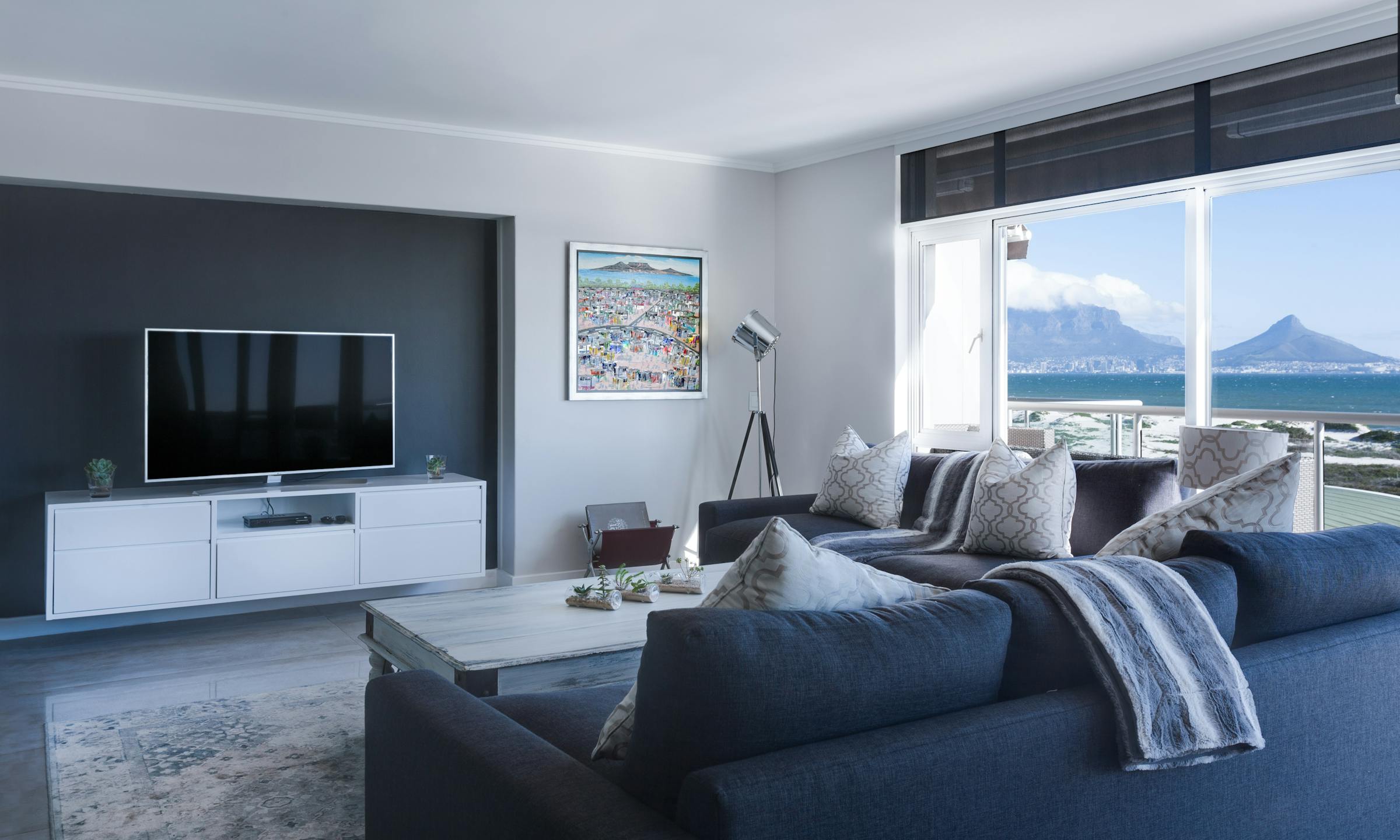Bright coastal-style living room with wide windows and airy palette
