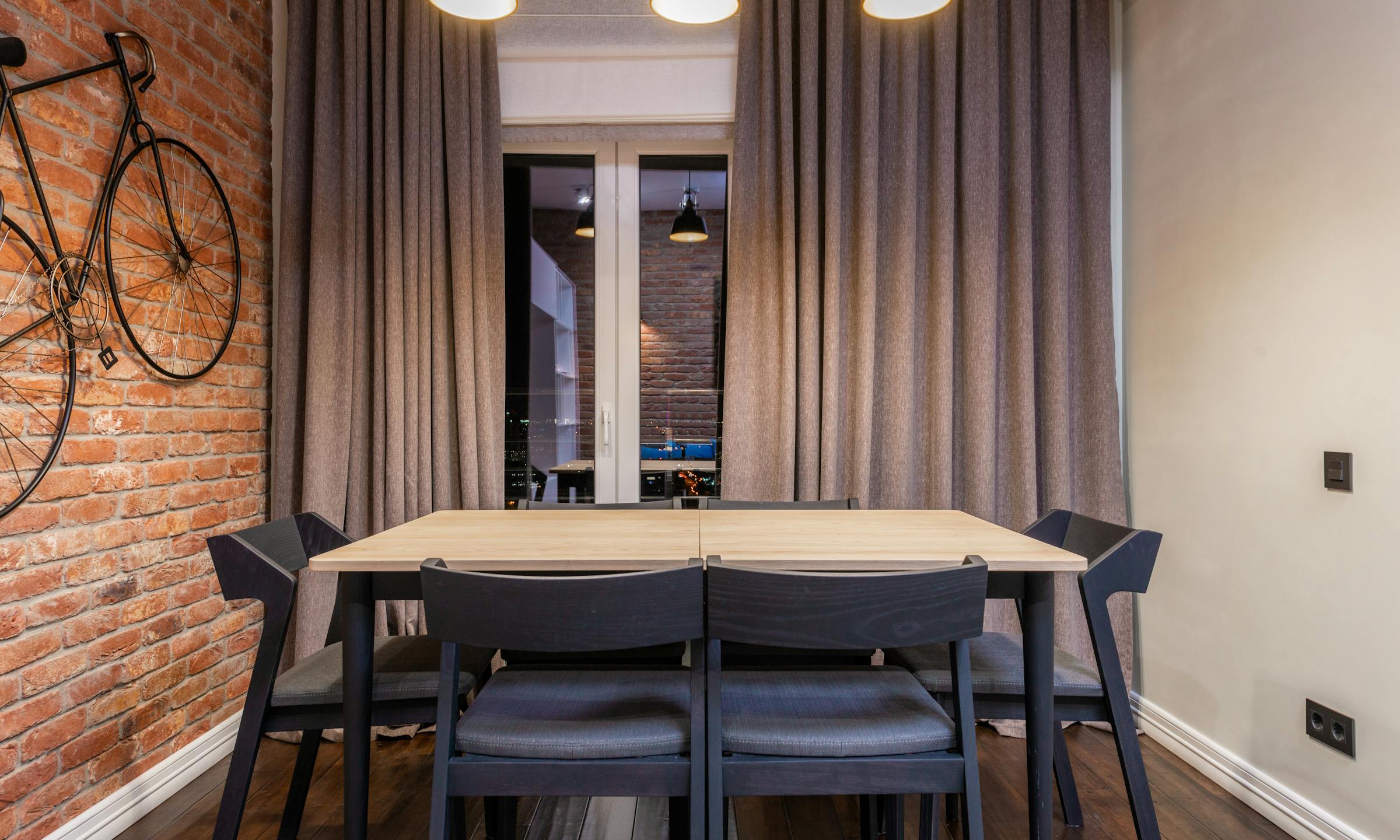 Modern dining interior with layered lighting and polished finishes