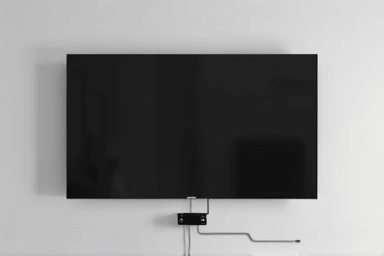 Close-up of a wall with concealed TV cables and set-top box.
