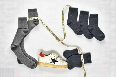 Socks and measuring tape around a Golden Goose sneaker.