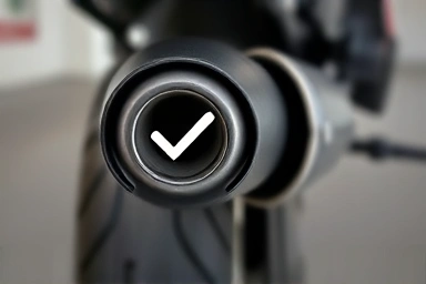Motorcycle exhaust pipe with a pass checkmark, symbolizing successful inspection.