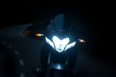 Bright motorcycle LED headlight illuminating a dark road at night.
