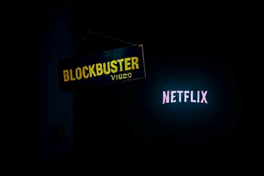 Fading Blockbuster store sign contrasted with glowing Netflix interface.