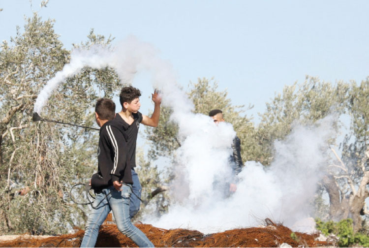 فلسطينيون في مواجهات مع قوات الاحتلال في قرية بيتا في الضفة الغربية - (ا ف ب)