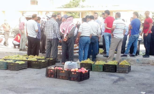 أشخاص أثناء تسوقهم لمنتجات المزارعين المعروضة على الشارع العام بعجلون-(الغد)