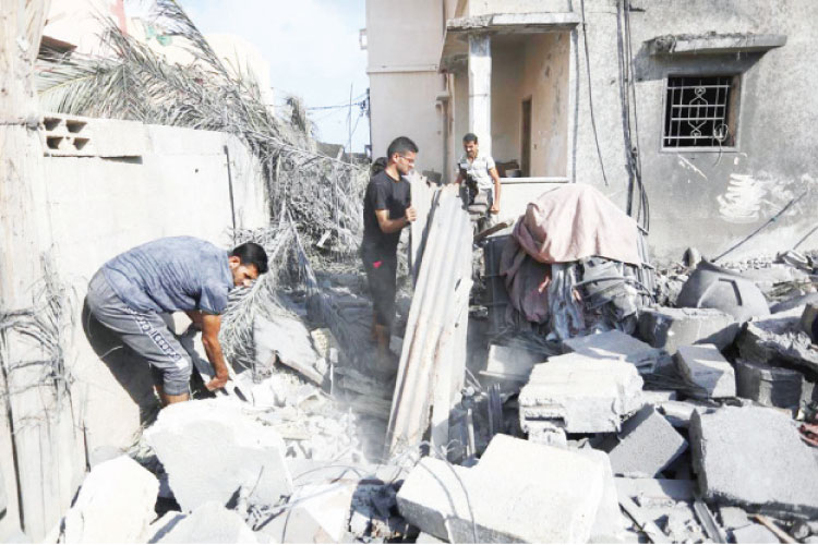 فلسطينيون يتفقدون منازلهم المدمرة بعد انتهاء العدوان الإسرائيلي على غزة.-(وكالات)
