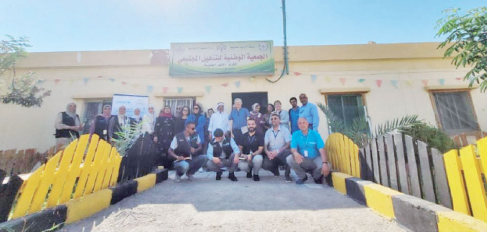 ناشطون وداعمون بمجال رعاية ذوي الإعاقة أمام مبنى الجمعية الوطنية للتأهيل المجتمعي بالأغوار الجنوبية-(الغد)