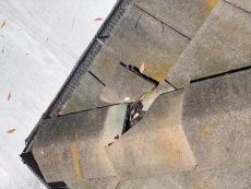 Roof inspected for solar panel installation shows broken roof tiles on the hip