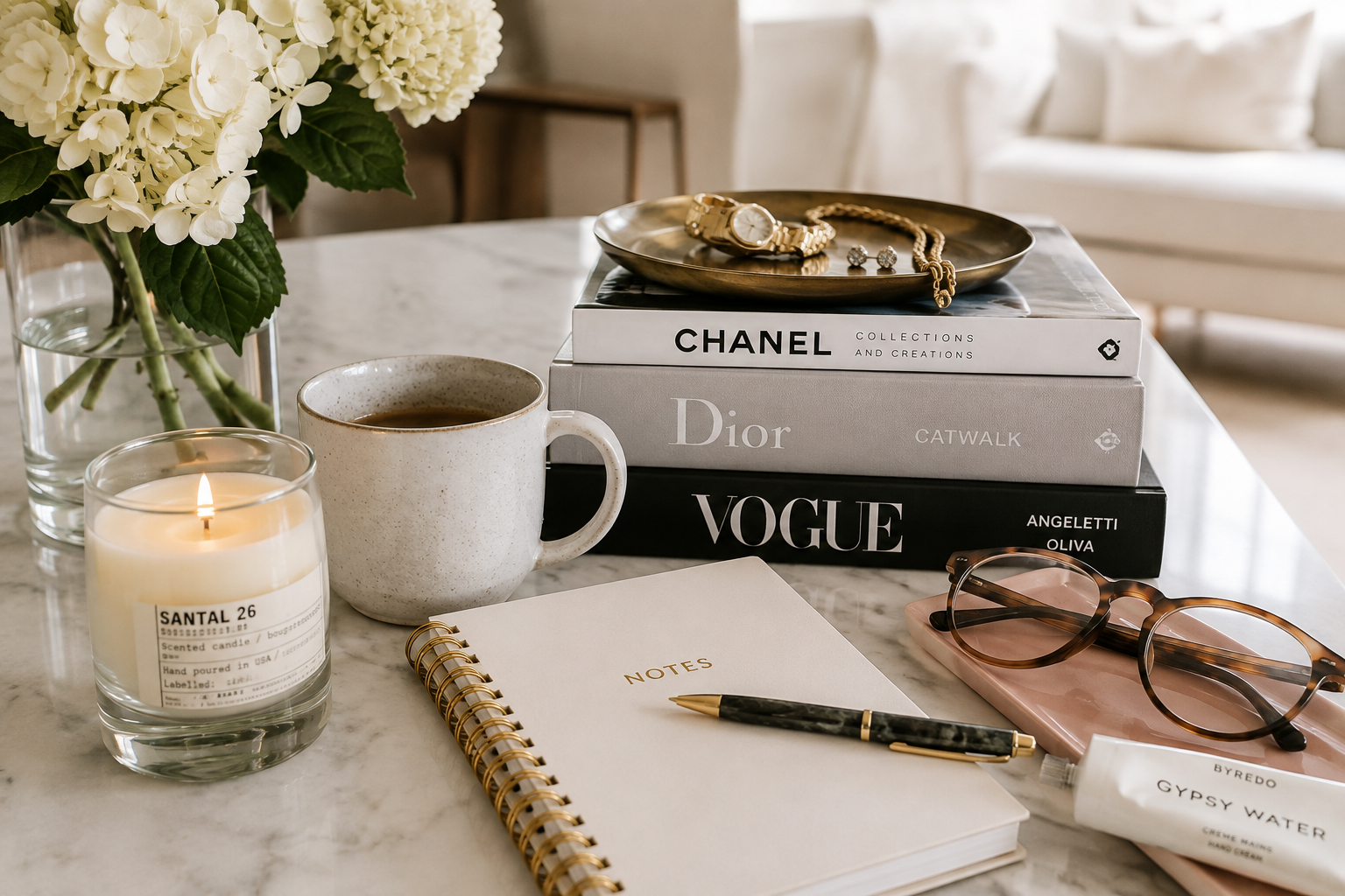 A notebook, sunglasses, jewelry, and coffee on Amelia's table
