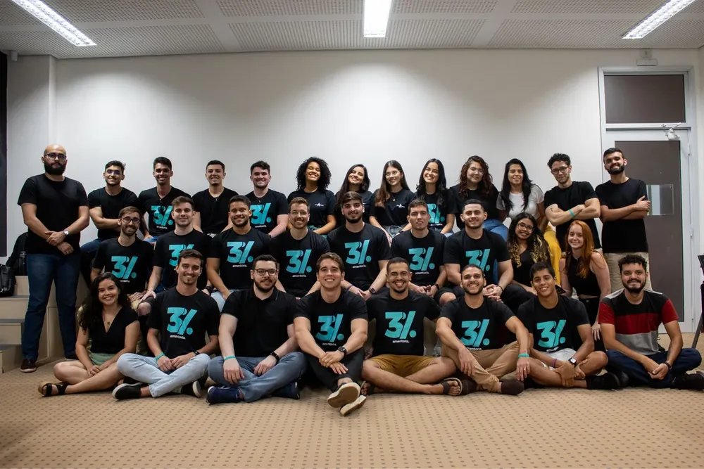 Time interno da AM reunido com a camisa da empresa