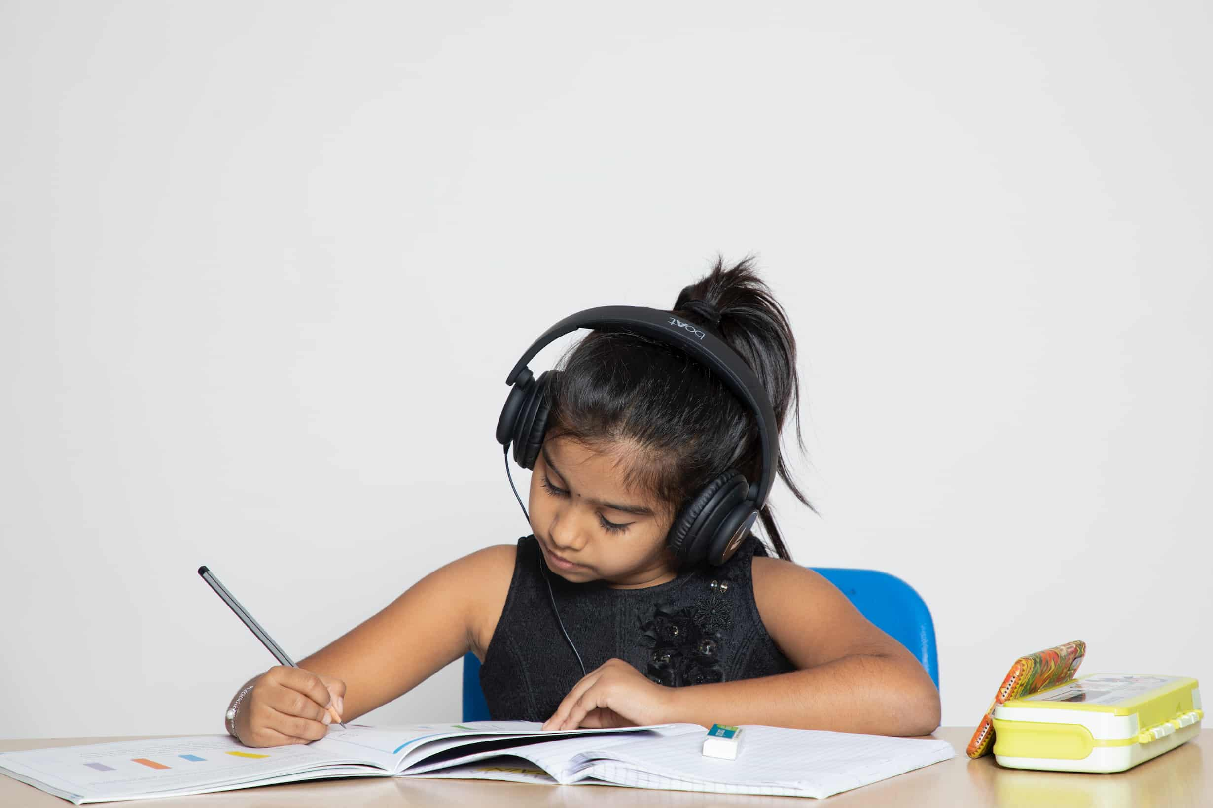 Girl finishing homework with headphone