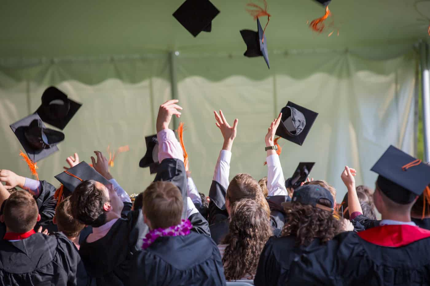 Graduates throwing cap in air