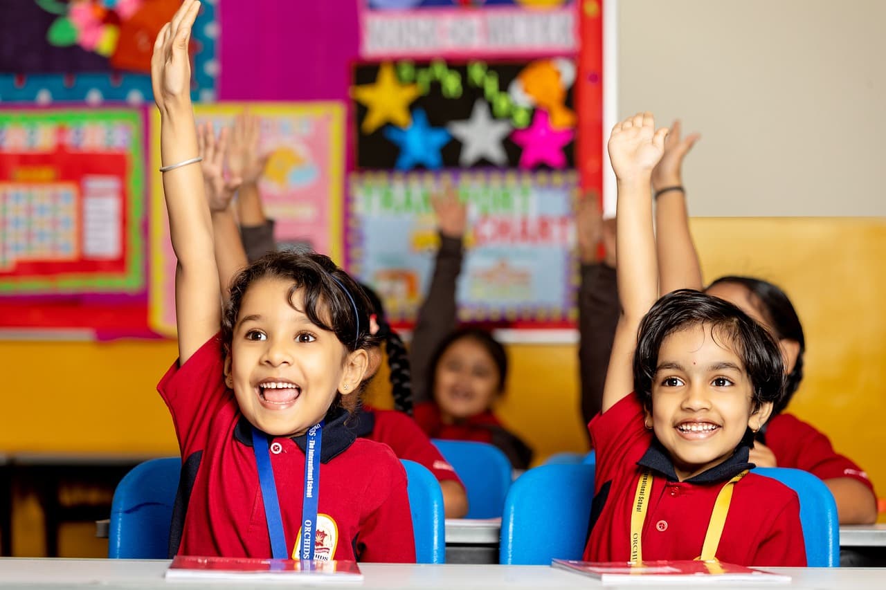 school student raising hands with happy face