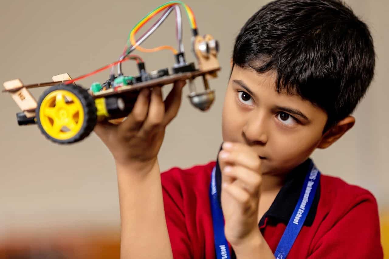 student examining DIY small car at school