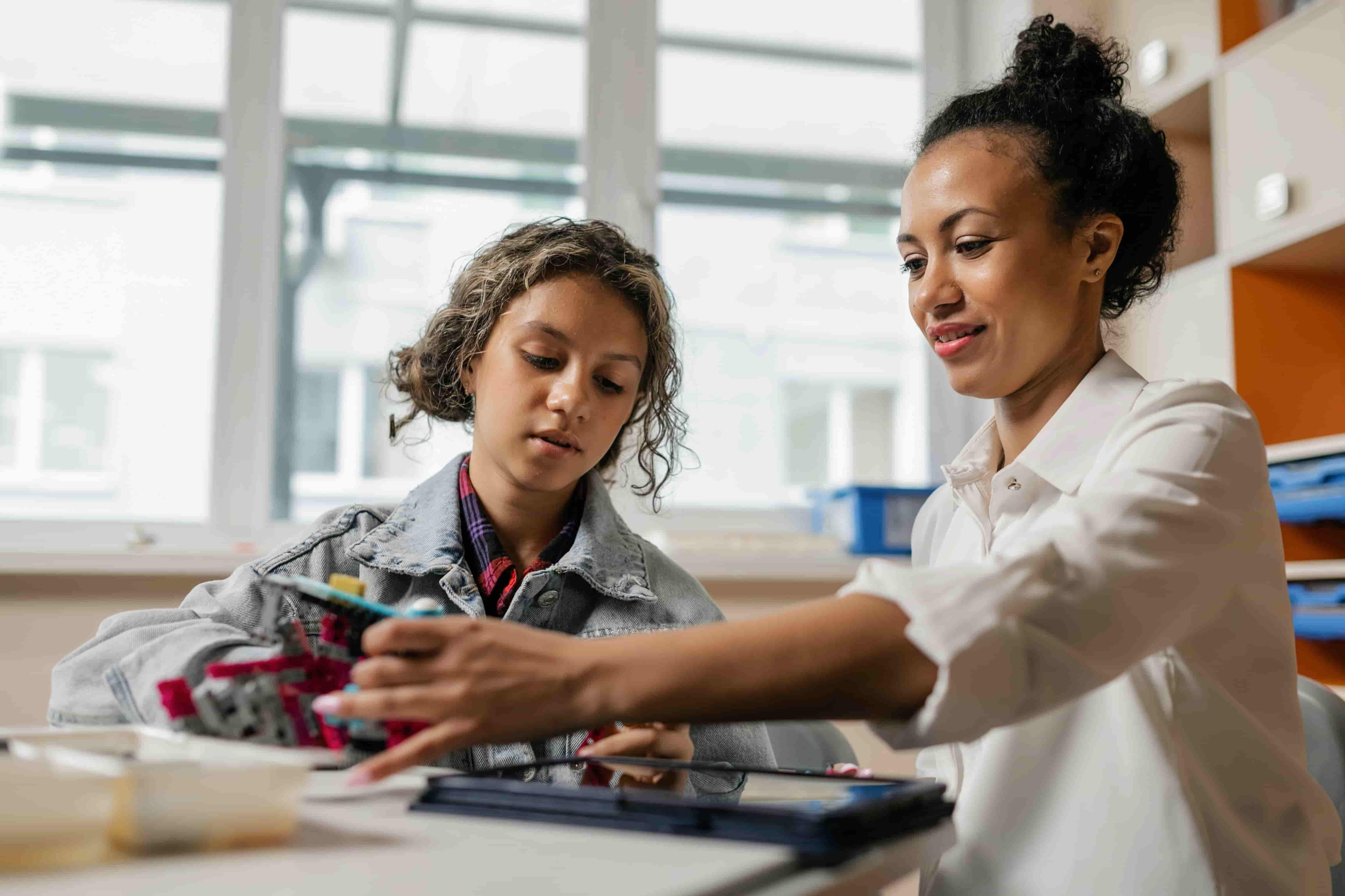 Teacher helping her student at class