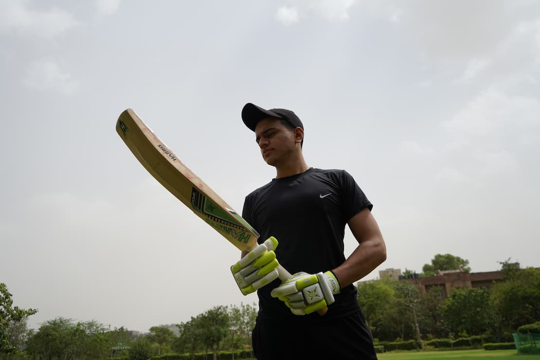 Young player Looking at his bat with confidence
