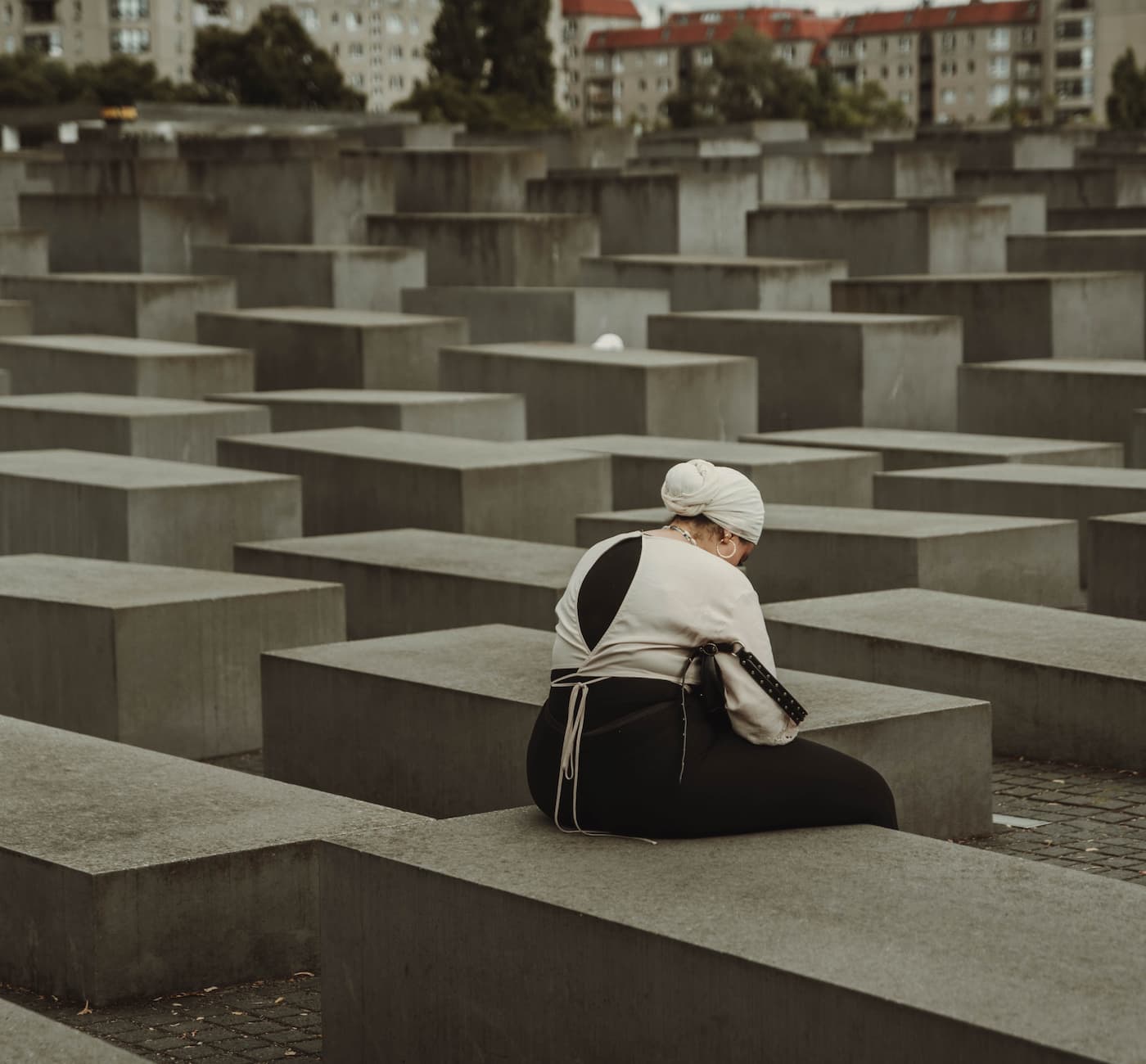 A women seated at the Holocaust memorial