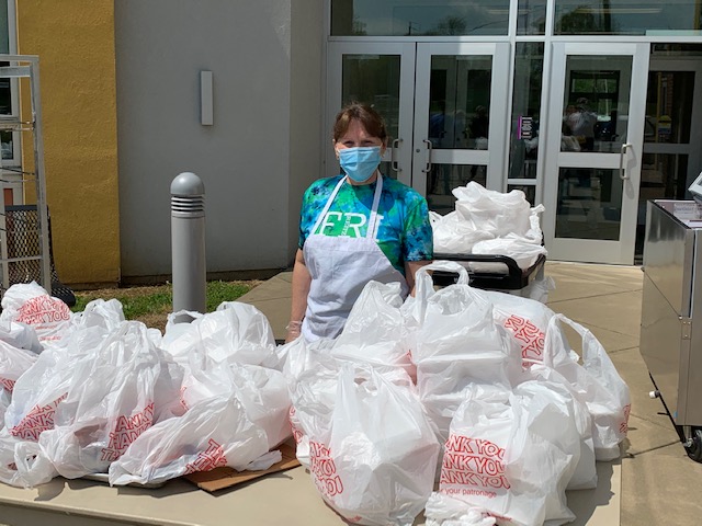 a volunteer of Tri-State Food Bank standing near some food packets