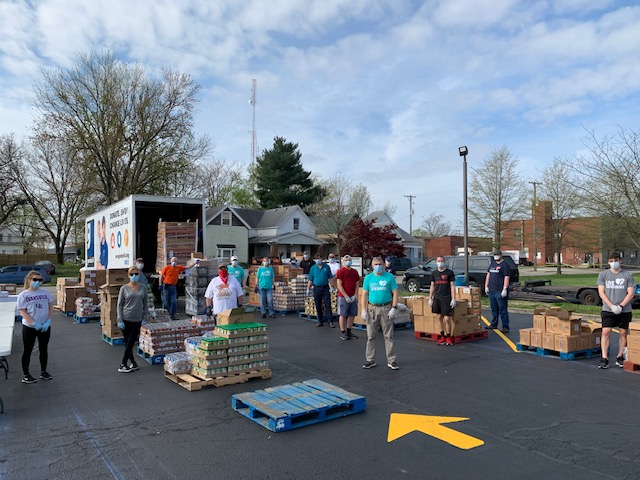 a group of people from Tri-State Food Bank and their food boxes