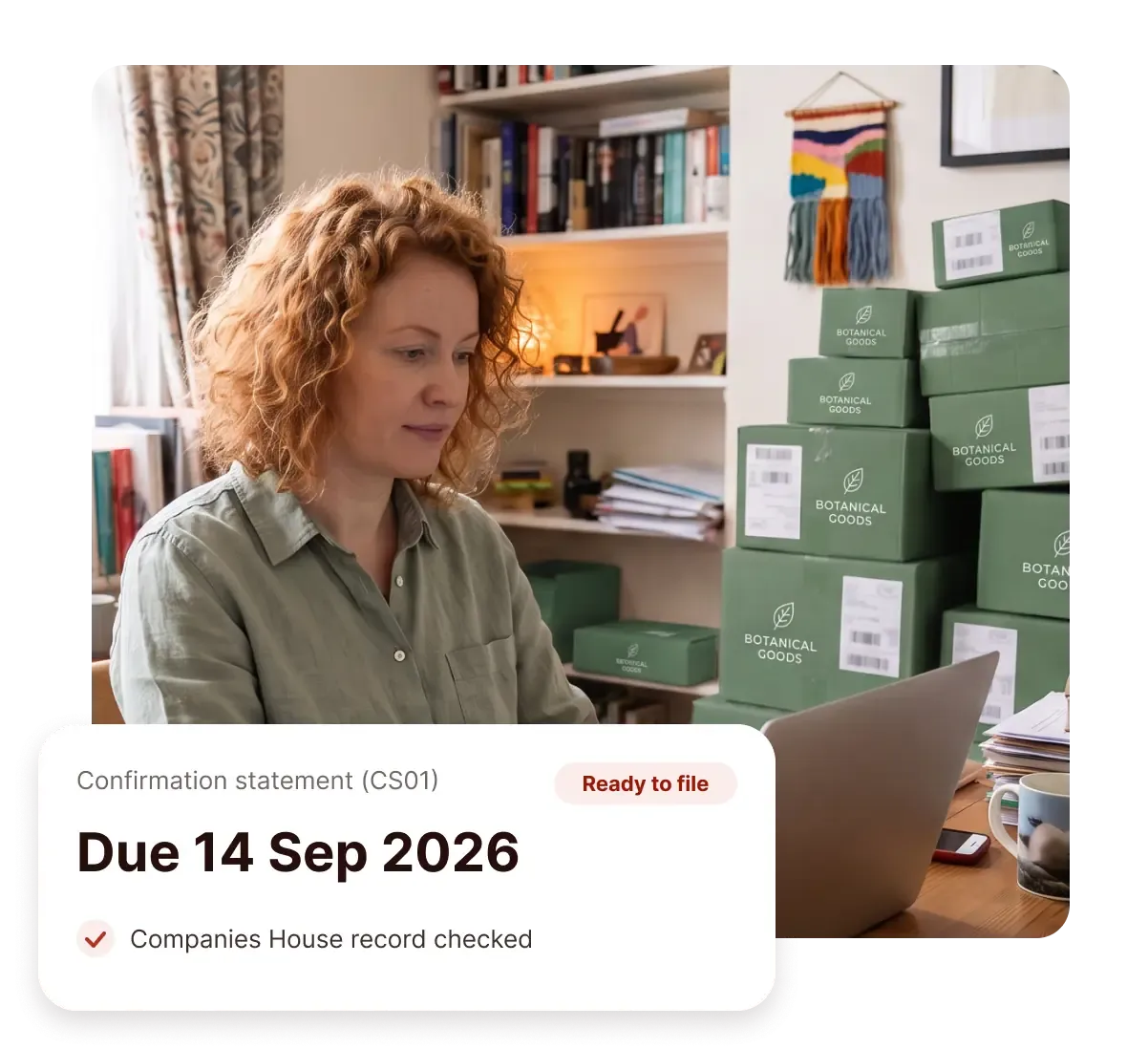 A business owner works on their laptop among stacked delivery boxes, next to a confirmation statement (CS01) card marked ready to file, due 14 September 2026, with their Companies House record checked
