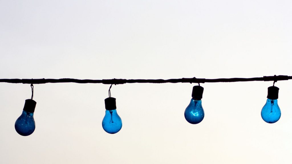 Blue bulbs hanging against the sky