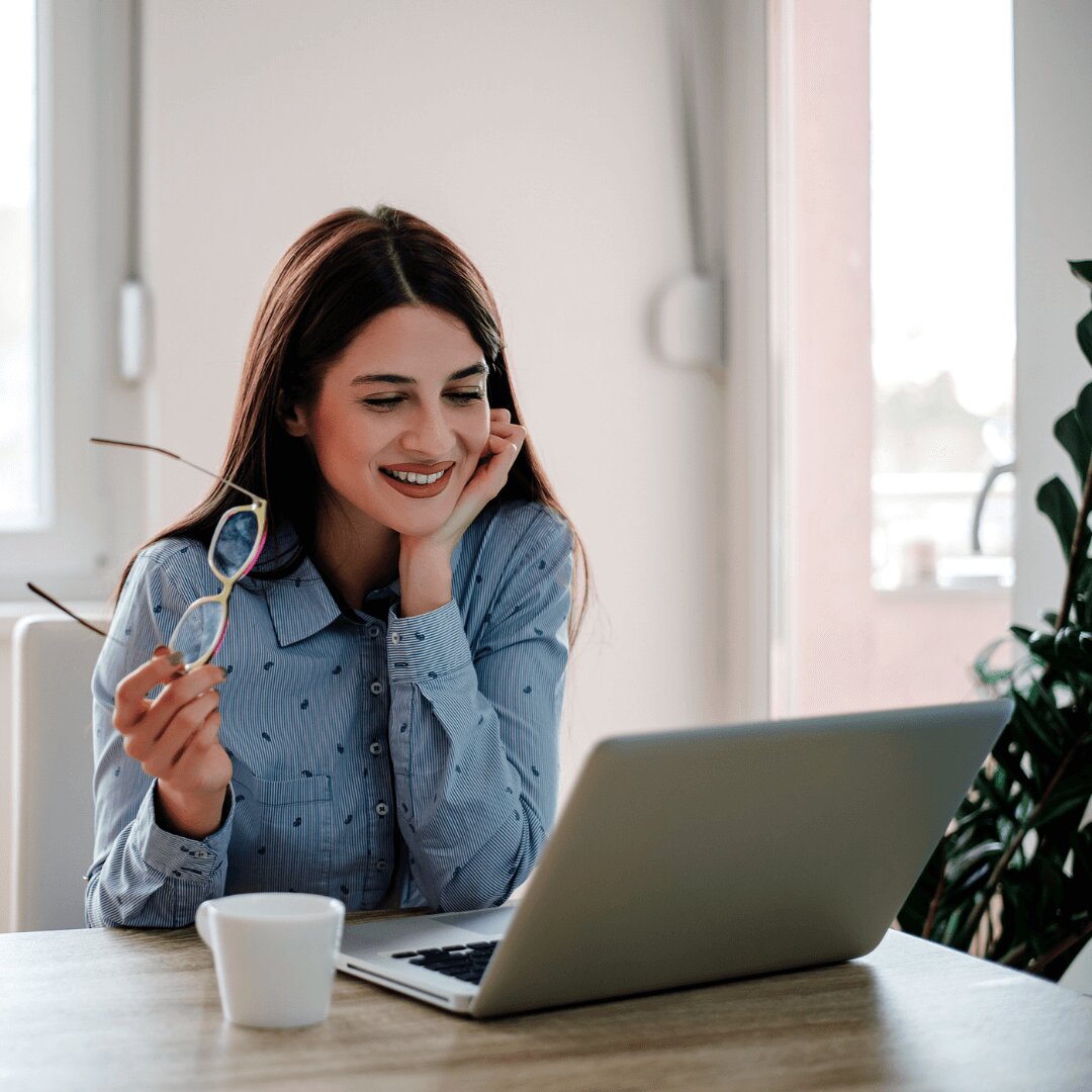 A smiling women watching something in the laptop