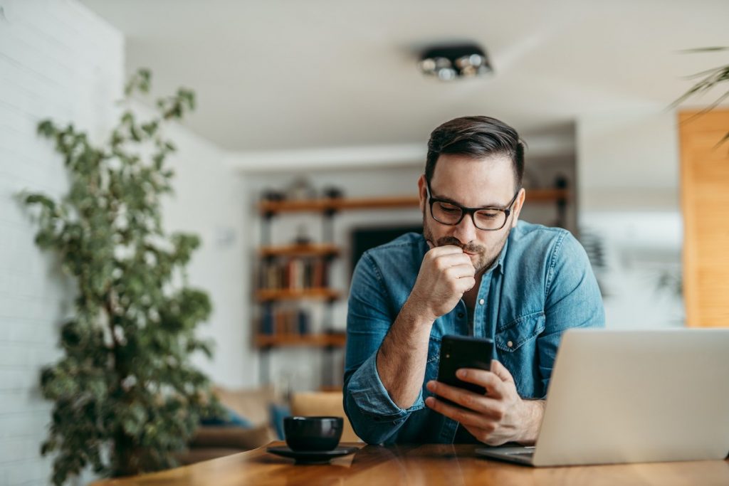 a man looking into his phone and trying to figure out something