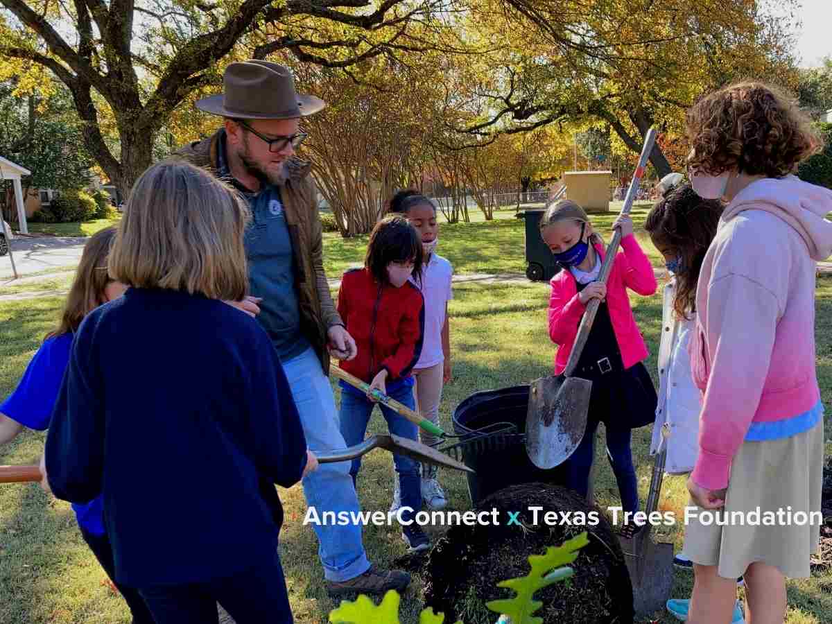 children and man planting trees together