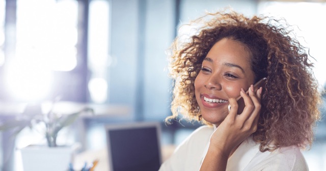 woman speaking on the phone and smiling delivering exceptional customer service