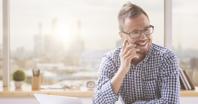 man speaking on the phone and smiling with live answering service