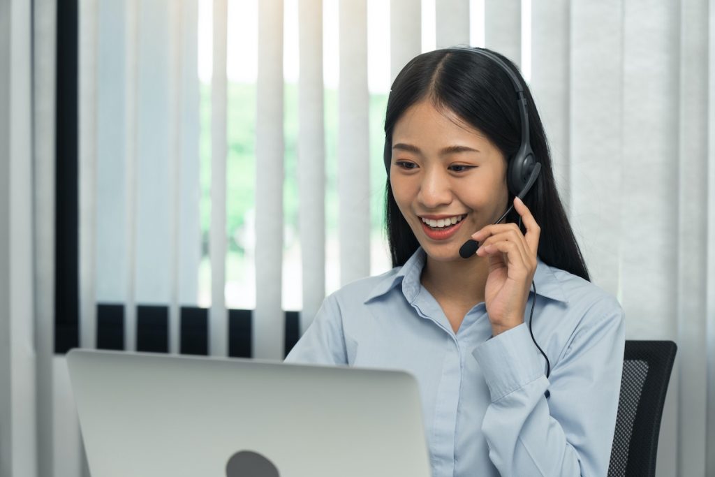 Close up call center worker smiling in his office.