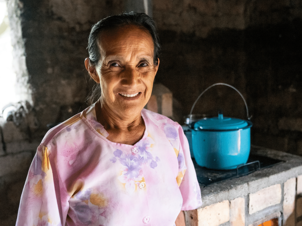 Older woman smiling in front of stove and new pot