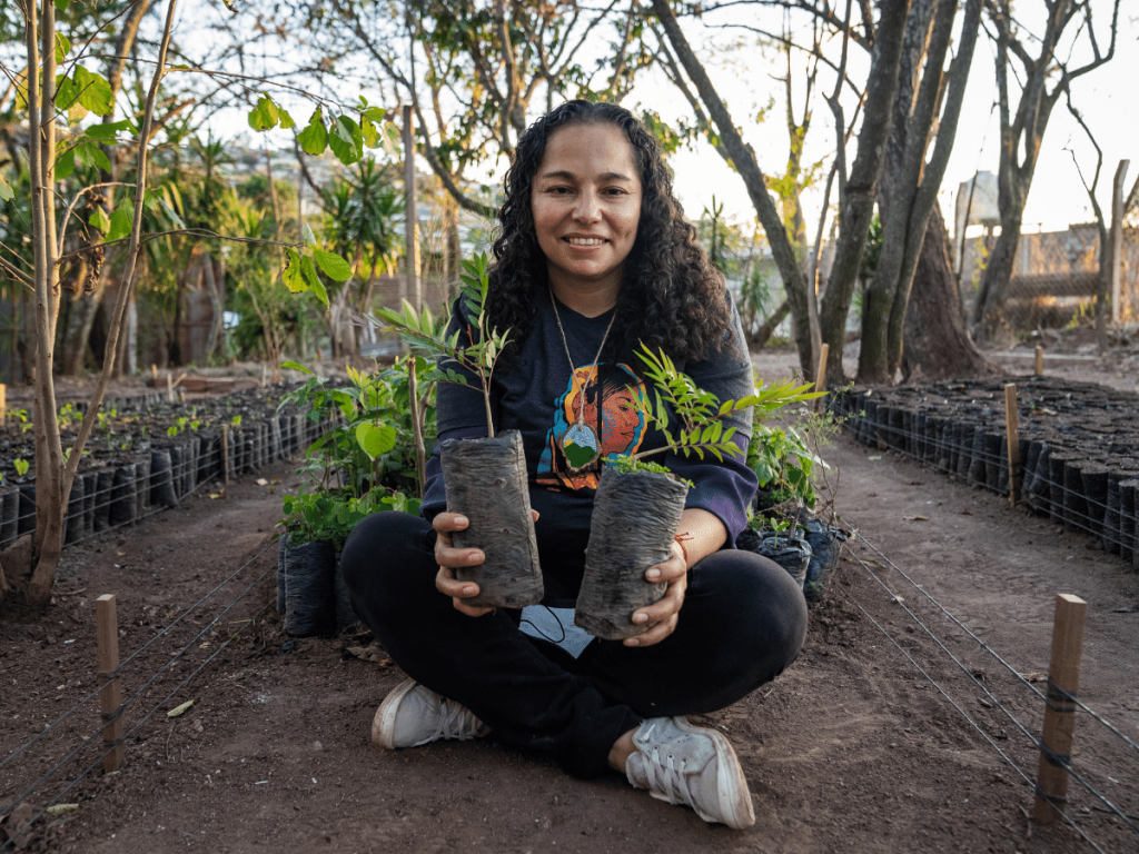 Girl holding two trees in a tree planting operations field