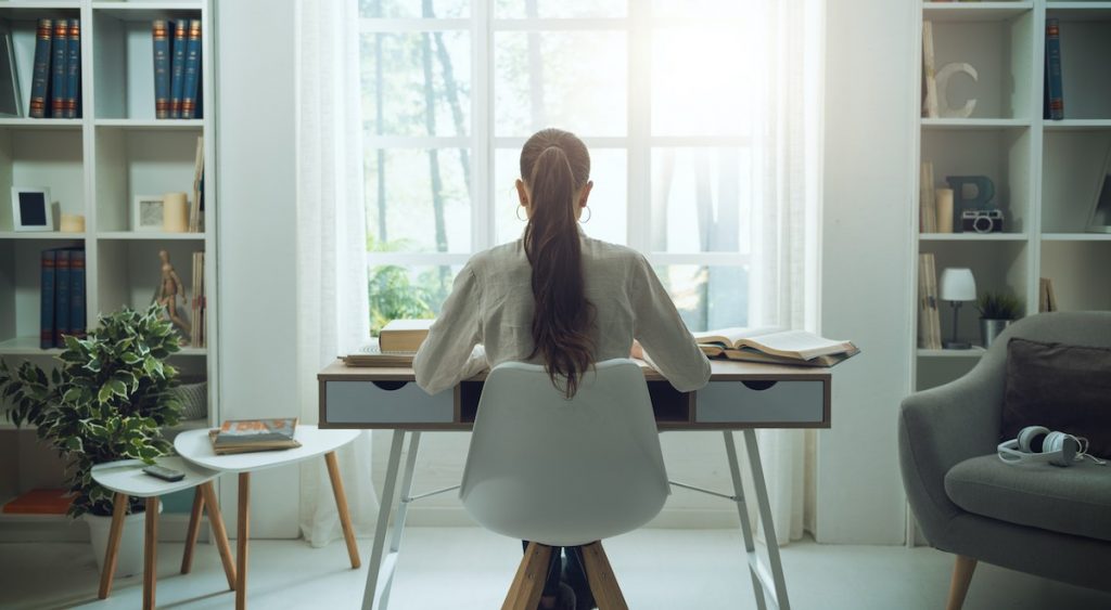 Young woman sitting at desk working in virtual call center